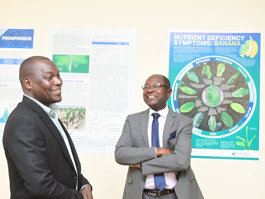 Two academics discussing research posters on crop nutrient deficiency