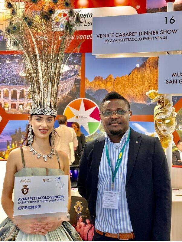 Standing beside a costumed performer at the Venice stand at ITB Berlin